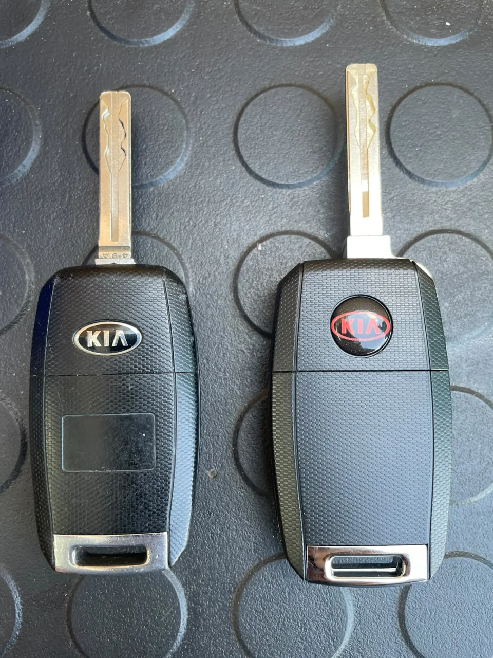 Two physical car flip-key shells on a dark surface